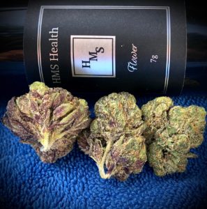 three buds of bully kush in front of hms bottle