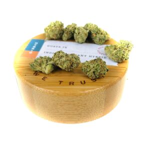 wooden lid of natures heritage 7 gram jar with buds of guava ix strain on top