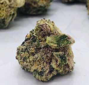 purple and green bud of gummiez showing many crystalline trichomes